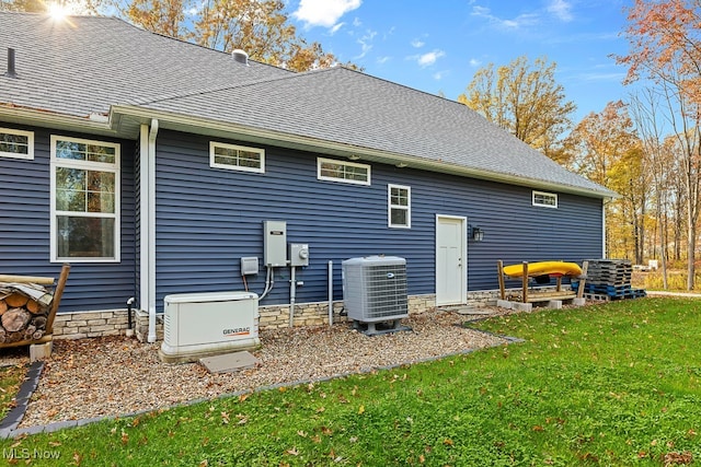 rear view of property featuring central AC and a yard