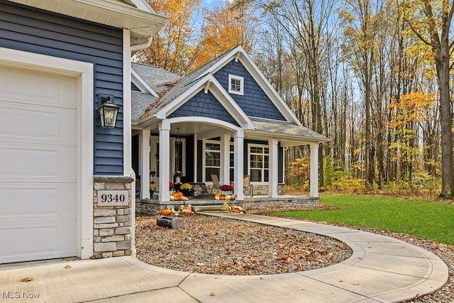 view of exterior entry with covered porch and a garage