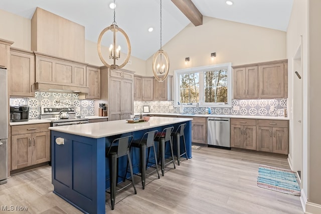 kitchen with a breakfast bar area, a kitchen island, tasteful backsplash, light hardwood / wood-style floors, and stainless steel appliances