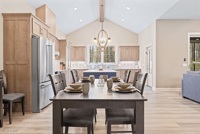 dining room with a notable chandelier, vaulted ceiling with beams, and light hardwood / wood-style flooring