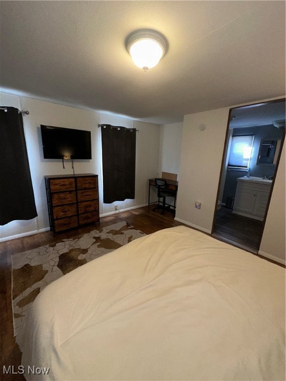 unfurnished bedroom with dark wood-type flooring and ensuite bathroom