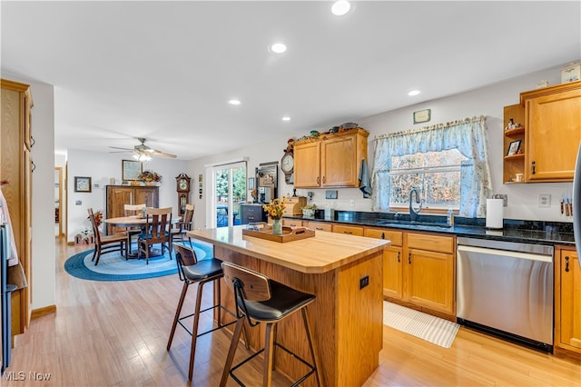 kitchen featuring light wood-type flooring, ceiling fan, sink, dishwasher, and a center island