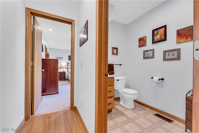 bathroom featuring hardwood / wood-style flooring and toilet