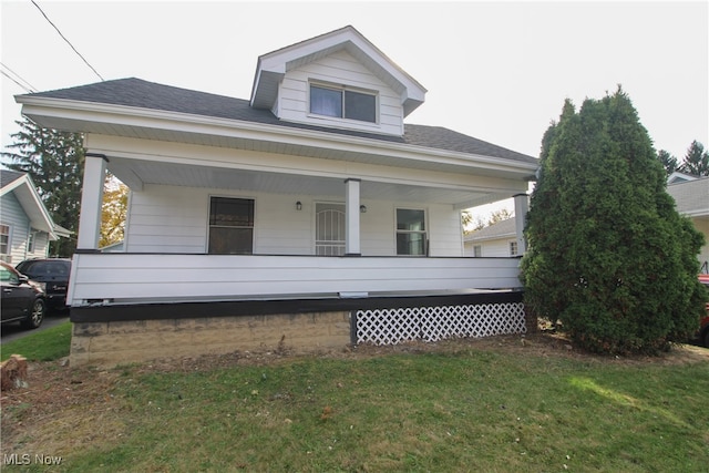 bungalow-style house featuring covered porch and a front yard