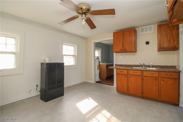 kitchen featuring heating unit, ceiling fan, water heater, ornamental molding, and sink