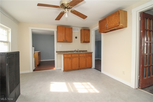 kitchen with light colored carpet, sink, and ceiling fan