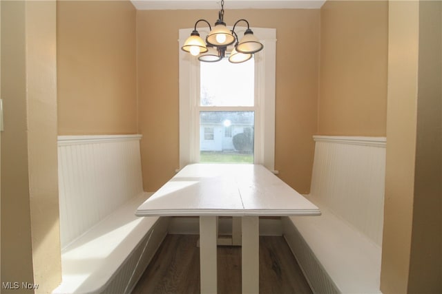 unfurnished dining area featuring a notable chandelier, dark hardwood / wood-style floors, and breakfast area