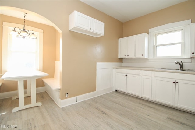 washroom featuring sink, a notable chandelier, and light hardwood / wood-style floors