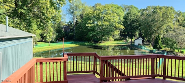 wooden deck with a water view and a lawn