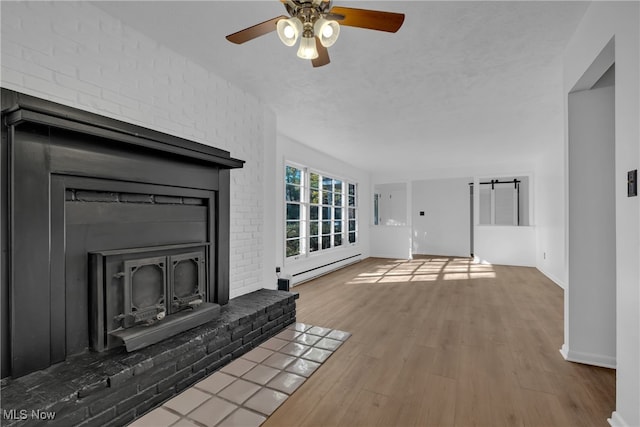 unfurnished living room featuring baseboard heating, hardwood / wood-style floors, a textured ceiling, and ceiling fan