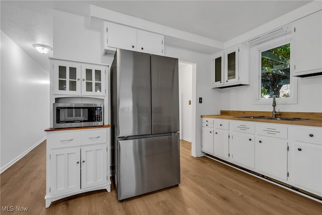 kitchen featuring light hardwood / wood-style floors, white cabinets, stainless steel appliances, and sink