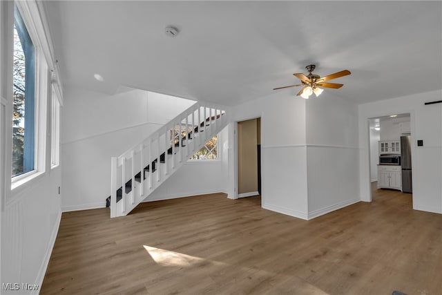 unfurnished living room with hardwood / wood-style flooring and ceiling fan