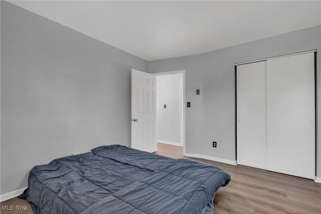 bedroom with hardwood / wood-style floors and a closet