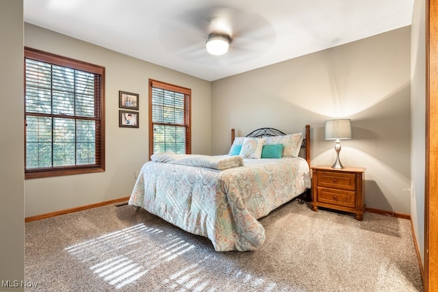 carpeted bedroom featuring ceiling fan and multiple windows