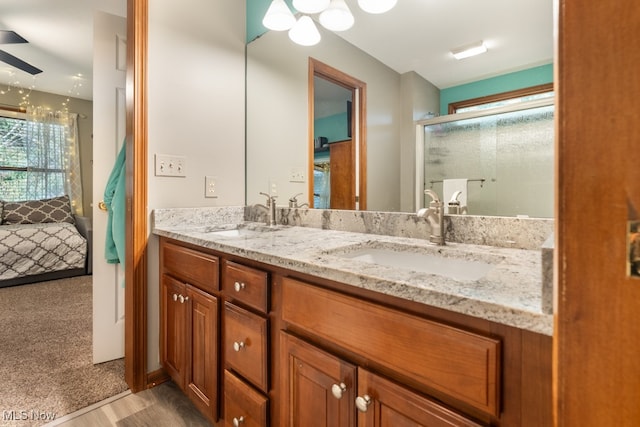 bathroom featuring hardwood / wood-style flooring, vanity, ceiling fan, and an enclosed shower