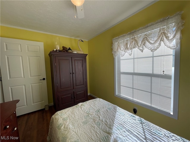 bedroom featuring dark hardwood / wood-style flooring, ornamental molding, a textured ceiling, and ceiling fan