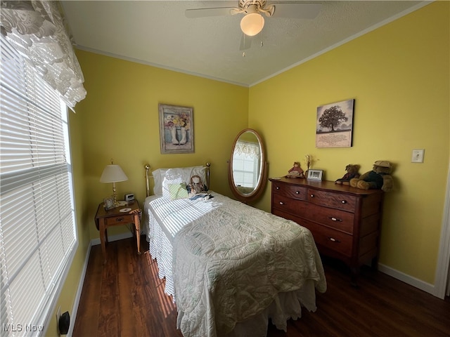 bedroom with dark wood-type flooring, crown molding, and ceiling fan