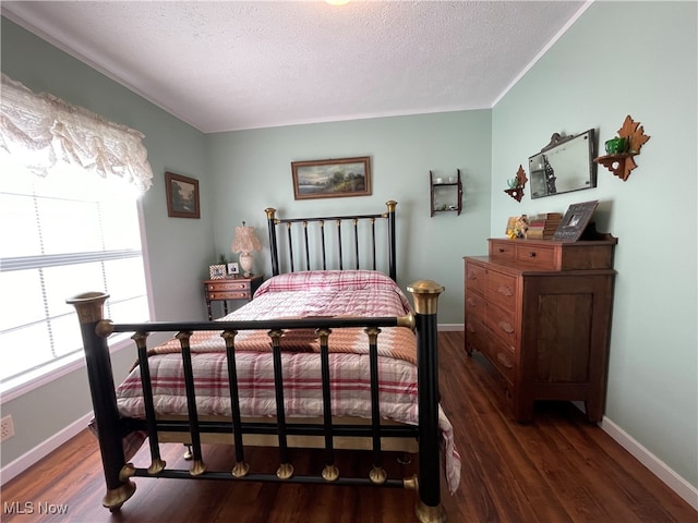 bedroom with a textured ceiling and dark hardwood / wood-style flooring