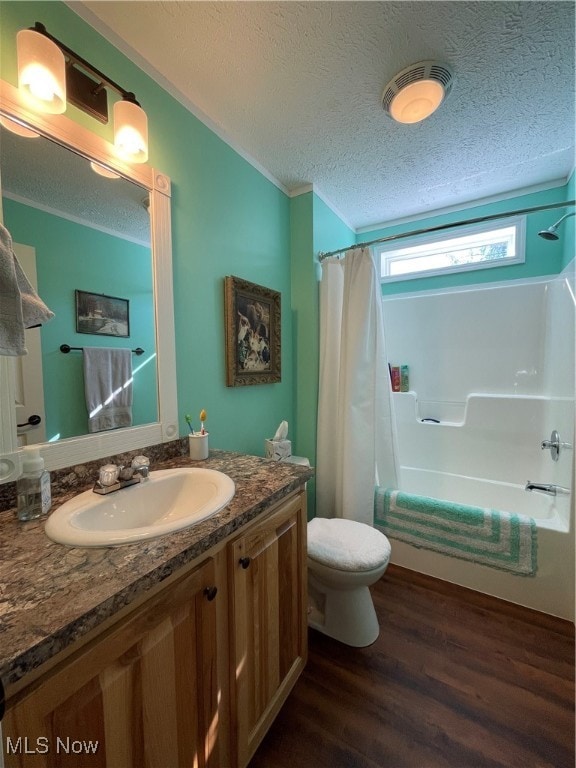 full bathroom with shower / bath combo, toilet, hardwood / wood-style floors, vanity, and a textured ceiling