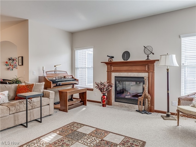 carpeted living room featuring a tiled fireplace