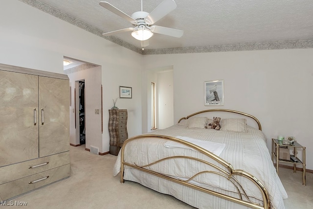 carpeted bedroom with a closet, a textured ceiling, and ceiling fan