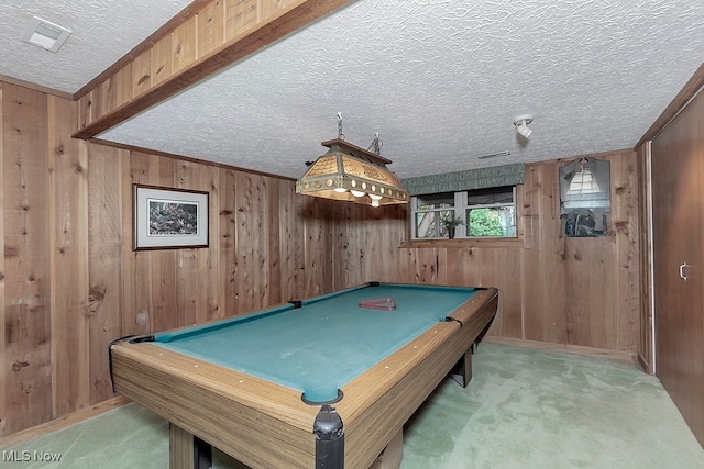 rec room featuring wood walls, a textured ceiling, and light colored carpet