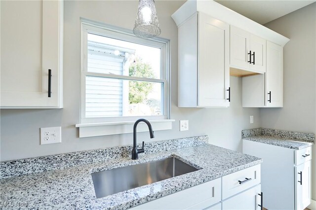 V/L E 344th St, Eastlake, OH 44095 - kitchen with a sink, light stone countertops, white cabinetry, and decorative light fixtures