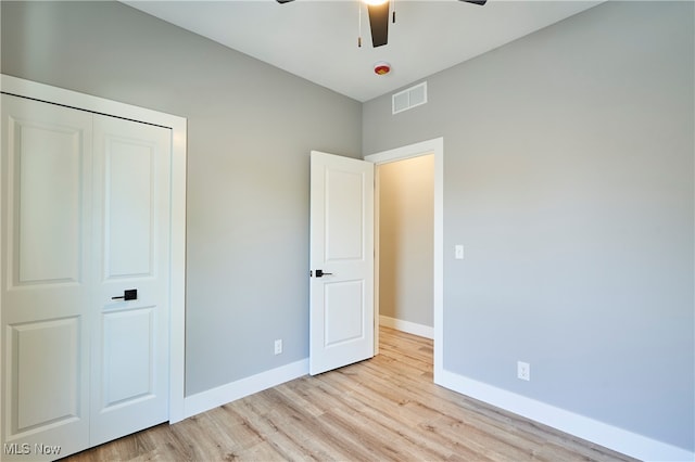 unfurnished bedroom with a closet, ceiling fan, and light hardwood / wood-style flooring