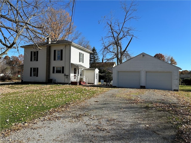 view of property featuring a front yard, central AC, an outbuilding, and a garage