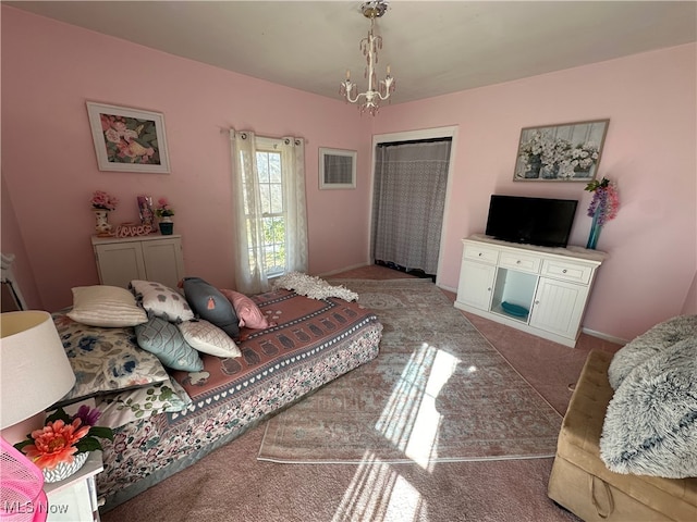 bedroom with a closet, carpet floors, and a chandelier