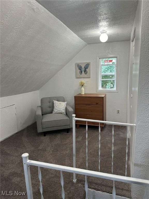 carpeted bedroom featuring vaulted ceiling and a textured ceiling