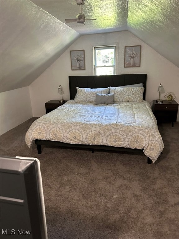 carpeted bedroom featuring a textured ceiling, vaulted ceiling, and ceiling fan