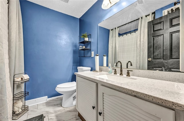 bathroom with vanity, a textured ceiling, and toilet