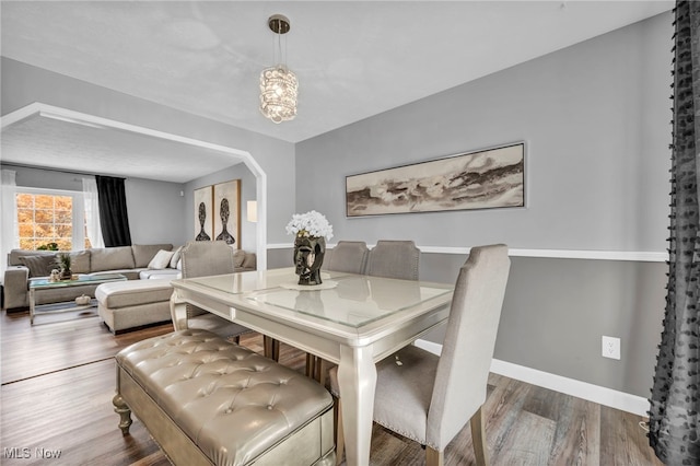 dining area featuring an inviting chandelier and hardwood / wood-style flooring