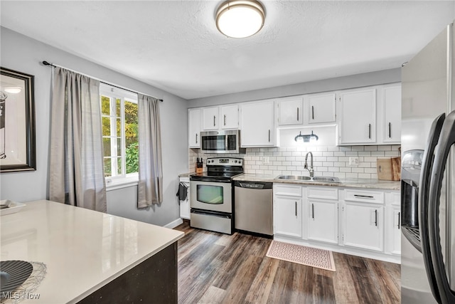 kitchen featuring white cabinetry, appliances with stainless steel finishes, sink, and dark hardwood / wood-style flooring