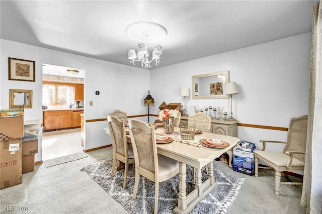 carpeted dining space with a chandelier