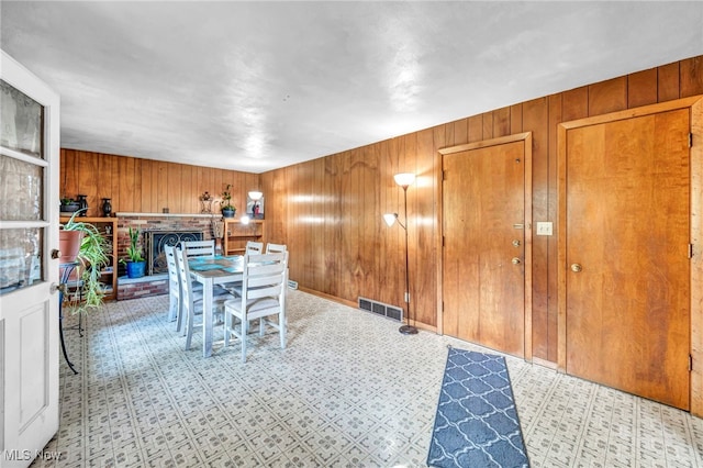 unfurnished dining area featuring wood walls and a fireplace