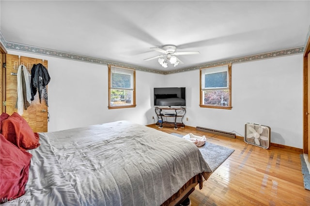 bedroom featuring ceiling fan, wood-type flooring, and a baseboard radiator