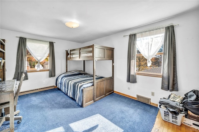 bedroom featuring baseboard heating and hardwood / wood-style flooring