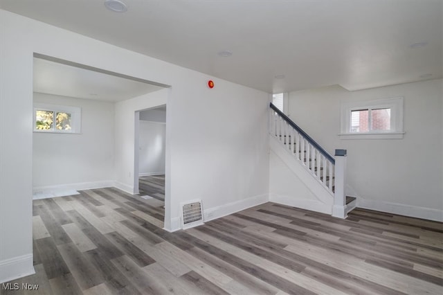 stairs with a healthy amount of sunlight and wood-type flooring