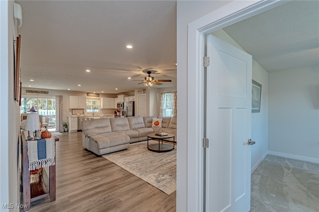 living room with light hardwood / wood-style floors and ceiling fan