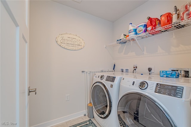 clothes washing area featuring washer and clothes dryer and light tile patterned floors