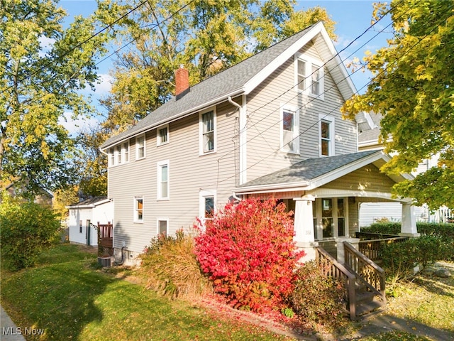 view of property exterior featuring covered porch and a lawn