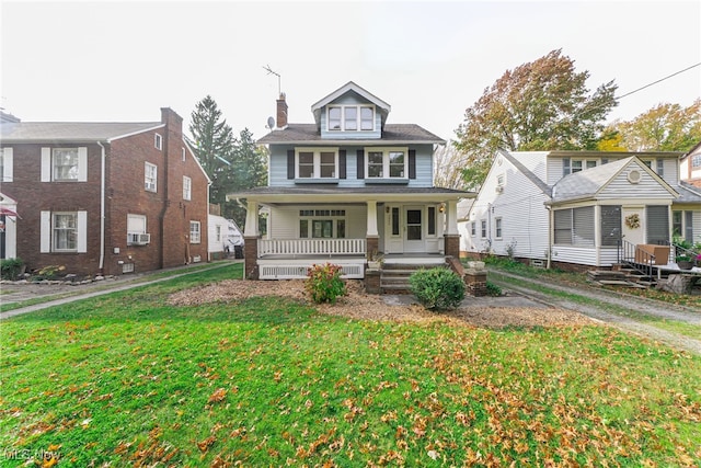 view of front of property featuring cooling unit, a front lawn, and covered porch