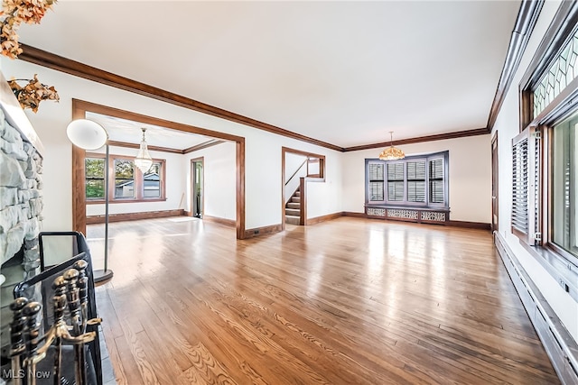 unfurnished living room with crown molding, a baseboard heating unit, and hardwood / wood-style floors