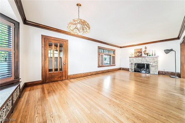 unfurnished living room with a fireplace, ornamental molding, and light wood-type flooring