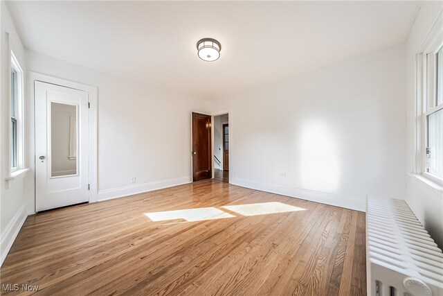 empty room with radiator and light wood-type flooring