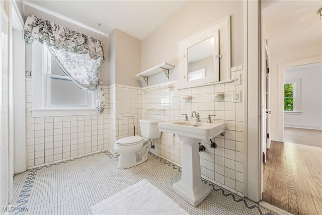 bathroom with tile walls, tile patterned flooring, and toilet