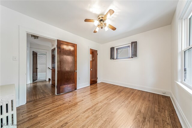 unfurnished bedroom with ceiling fan and light hardwood / wood-style flooring