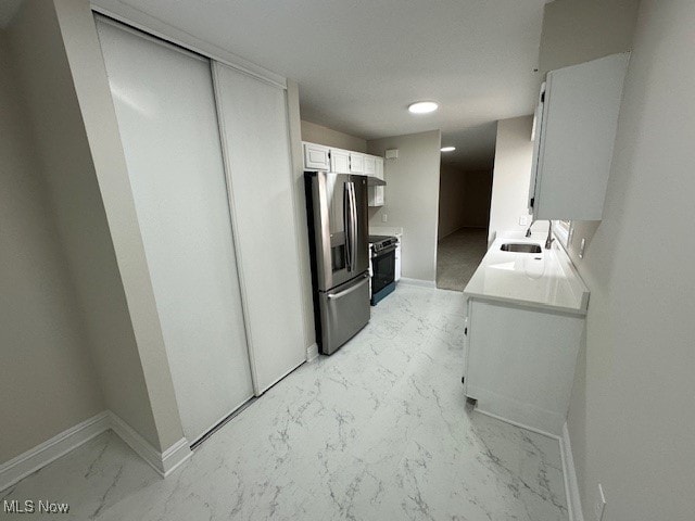 kitchen featuring stainless steel refrigerator with ice dispenser, white cabinets, sink, and black range with electric stovetop